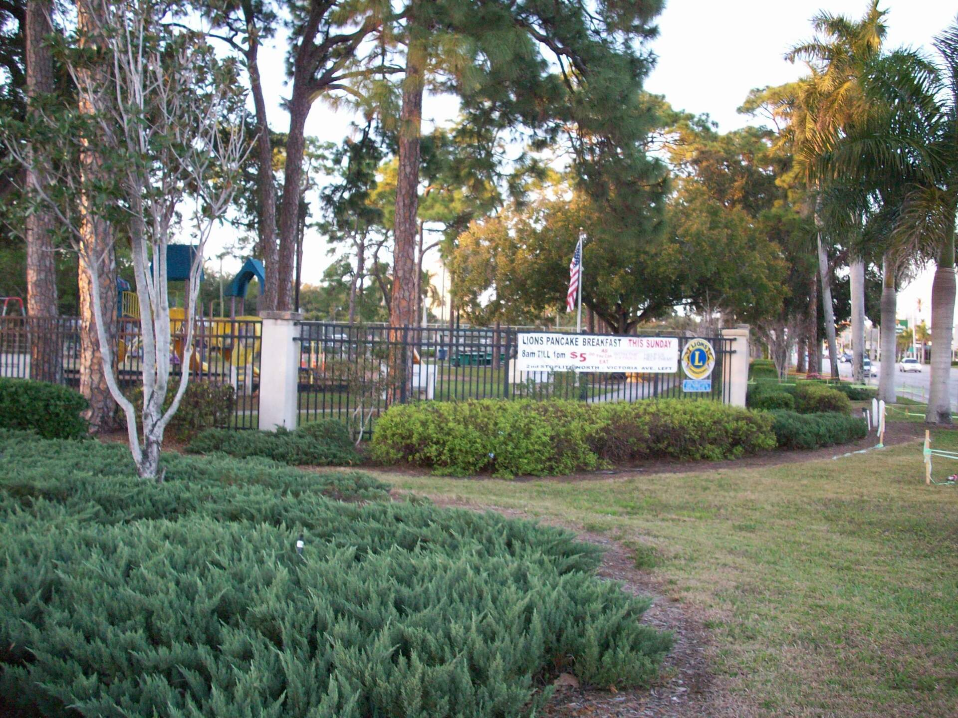 A park with trees and bushes and a sign that says freedom park