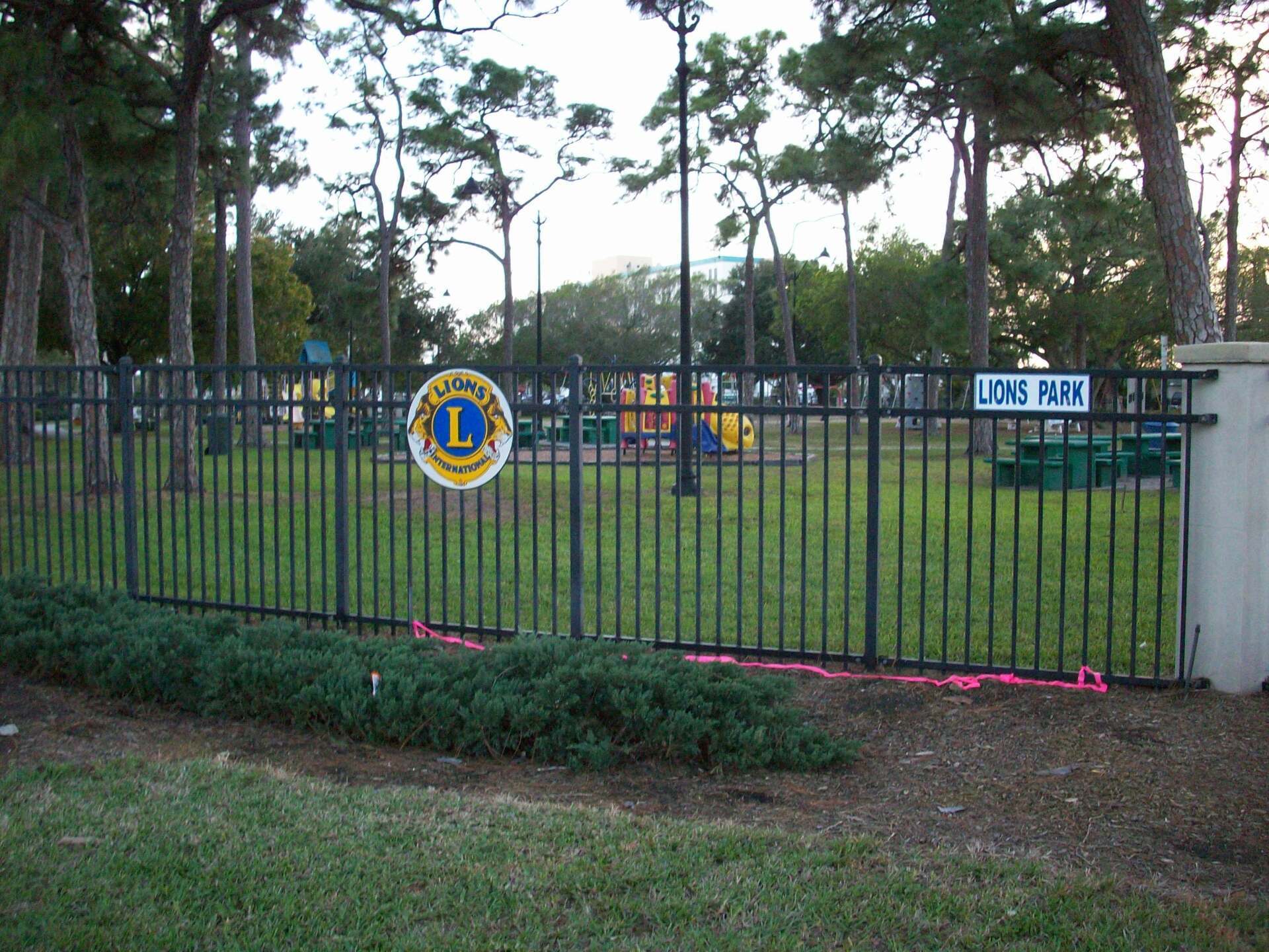 A fence with a sign that says lions park on it