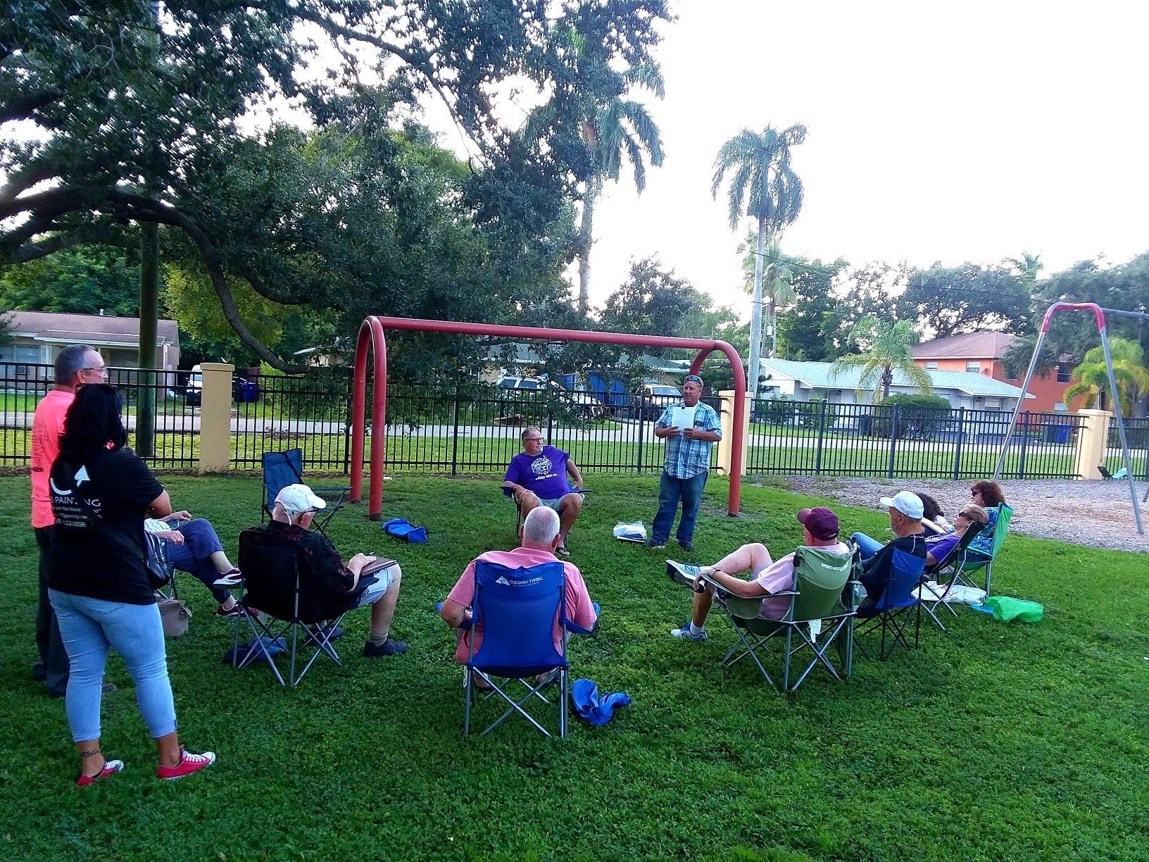 A group of people are sitting in a circle in a park