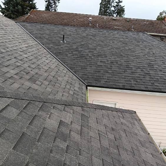 A close up of a roof of a house with a shingle roof.