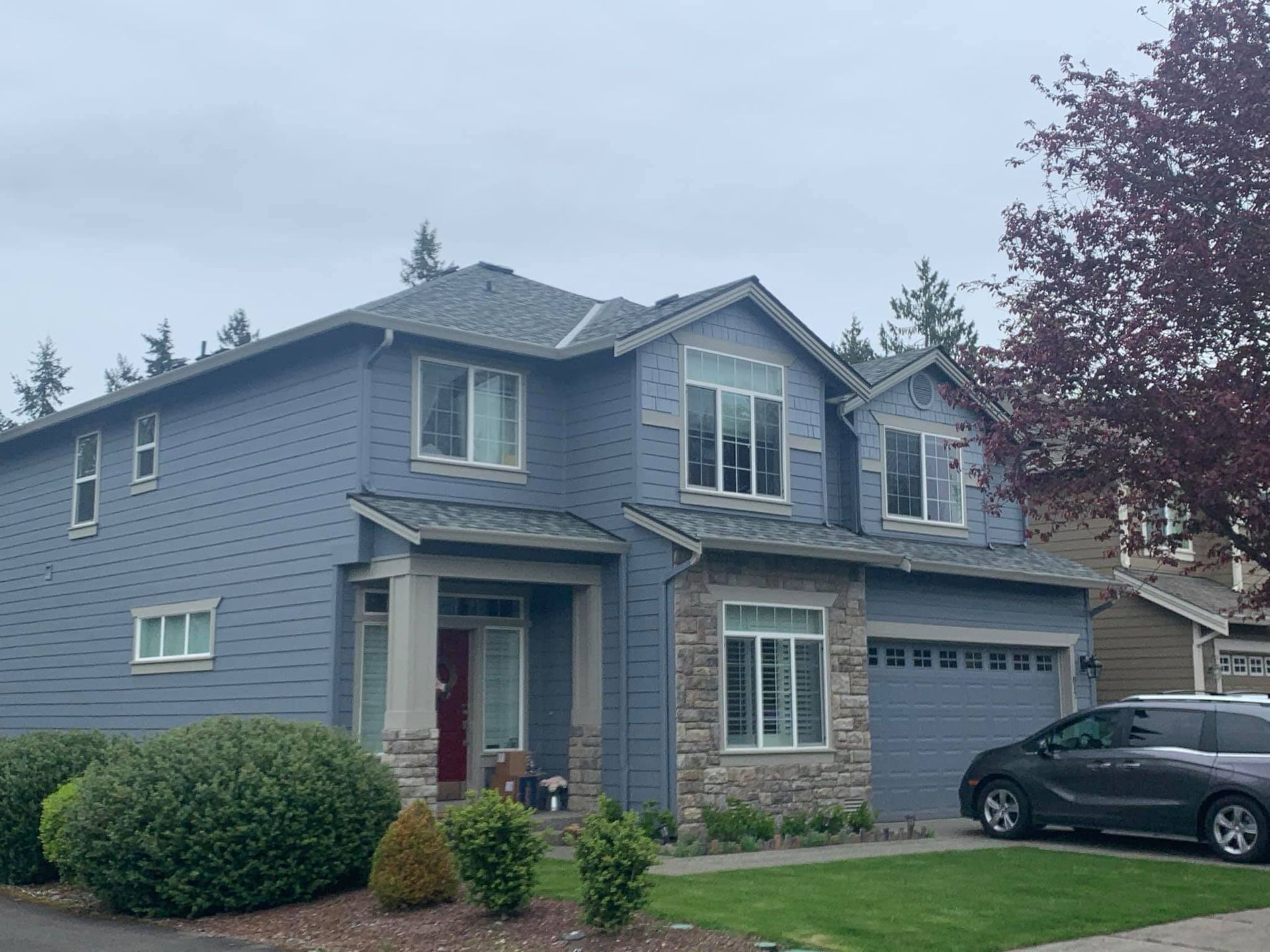 A blue house with a car parked in front of it