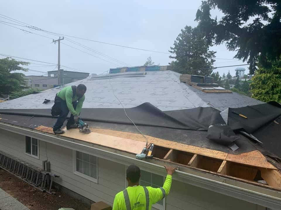 A man is working on the roof of a house.