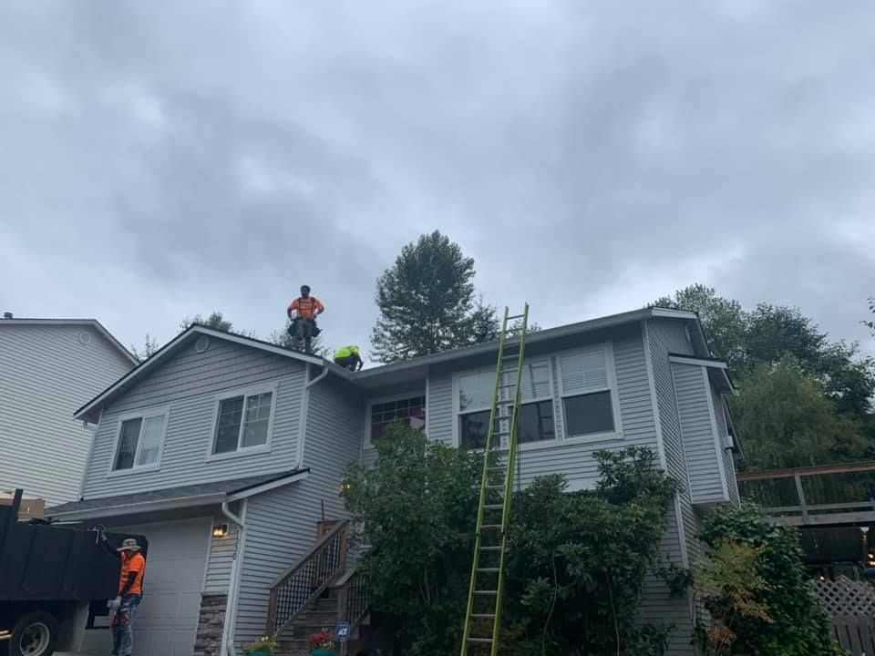 Two men are working on the roof of a house.