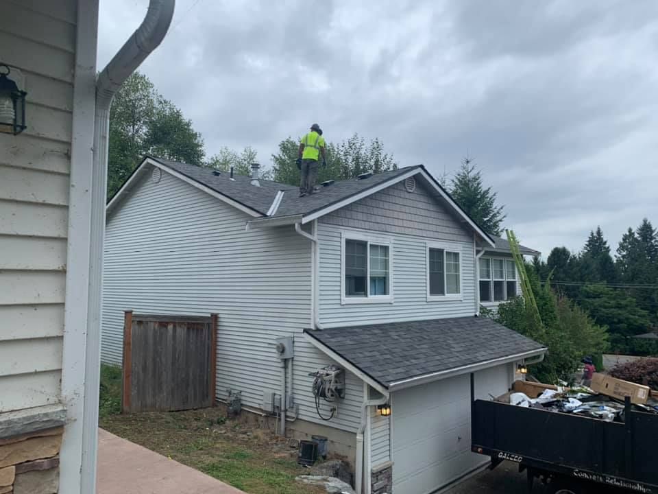 A man is standing on the roof of a house.