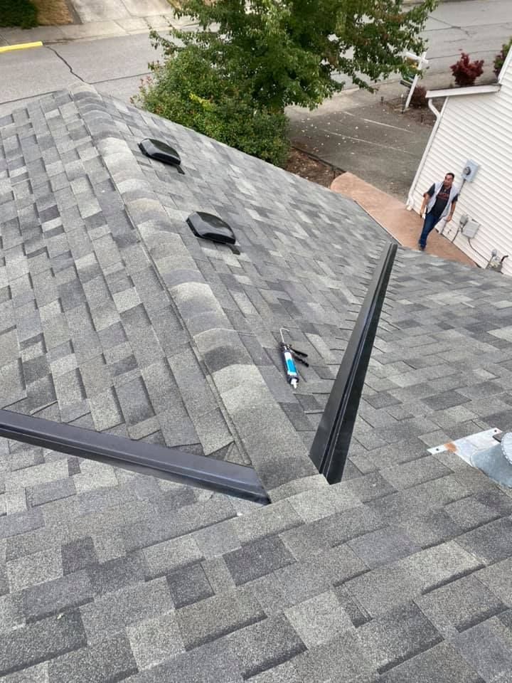 A man is standing on the roof of a house.
