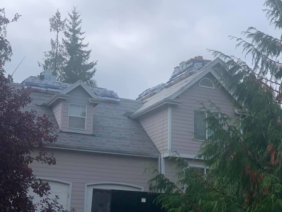 A house with a roof that has been damaged by a storm.