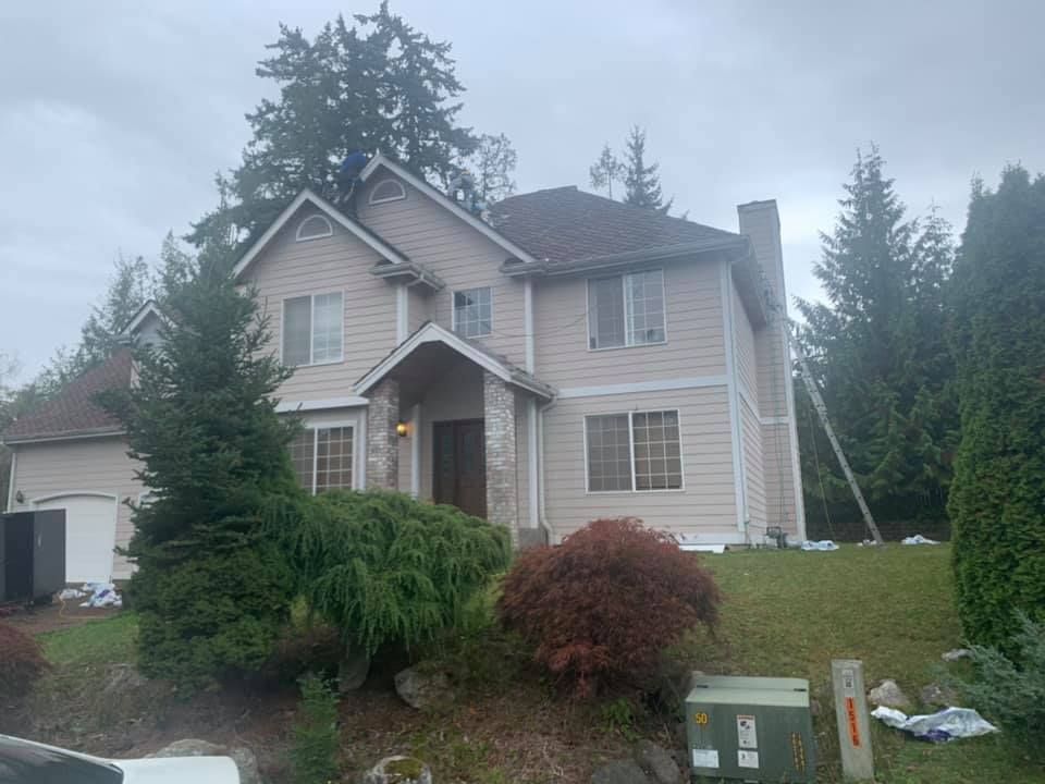 A large house is sitting on top of a lush green hillside.