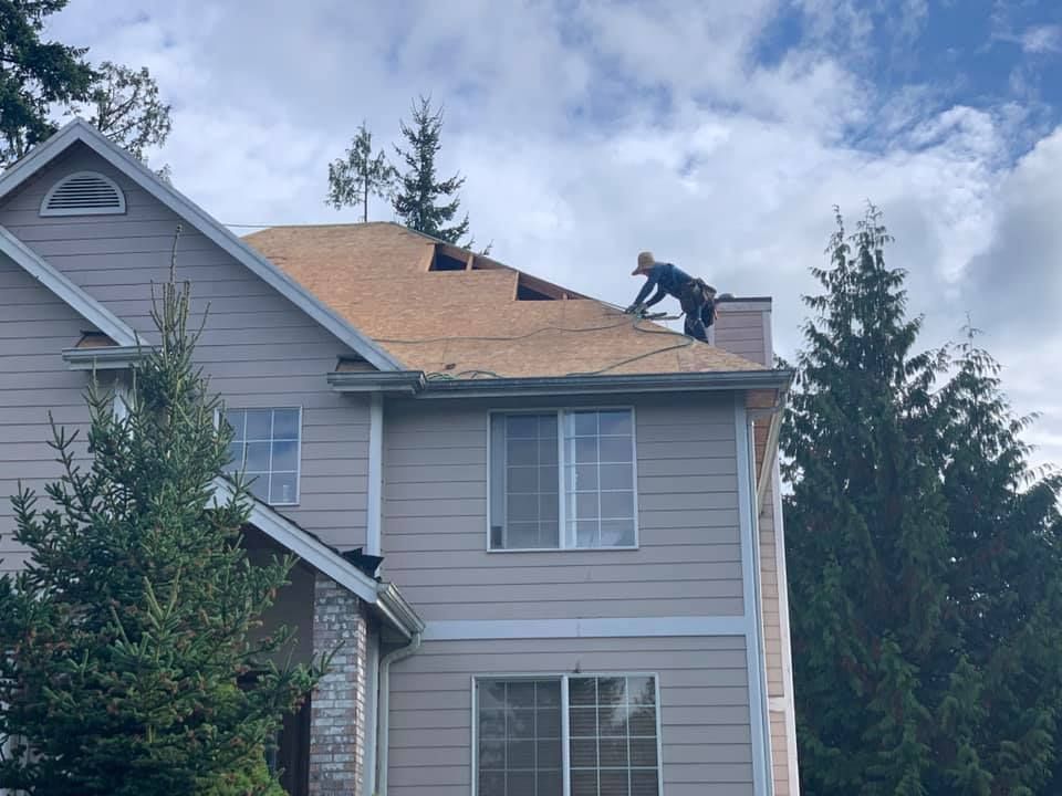 A man is working on the roof of a house