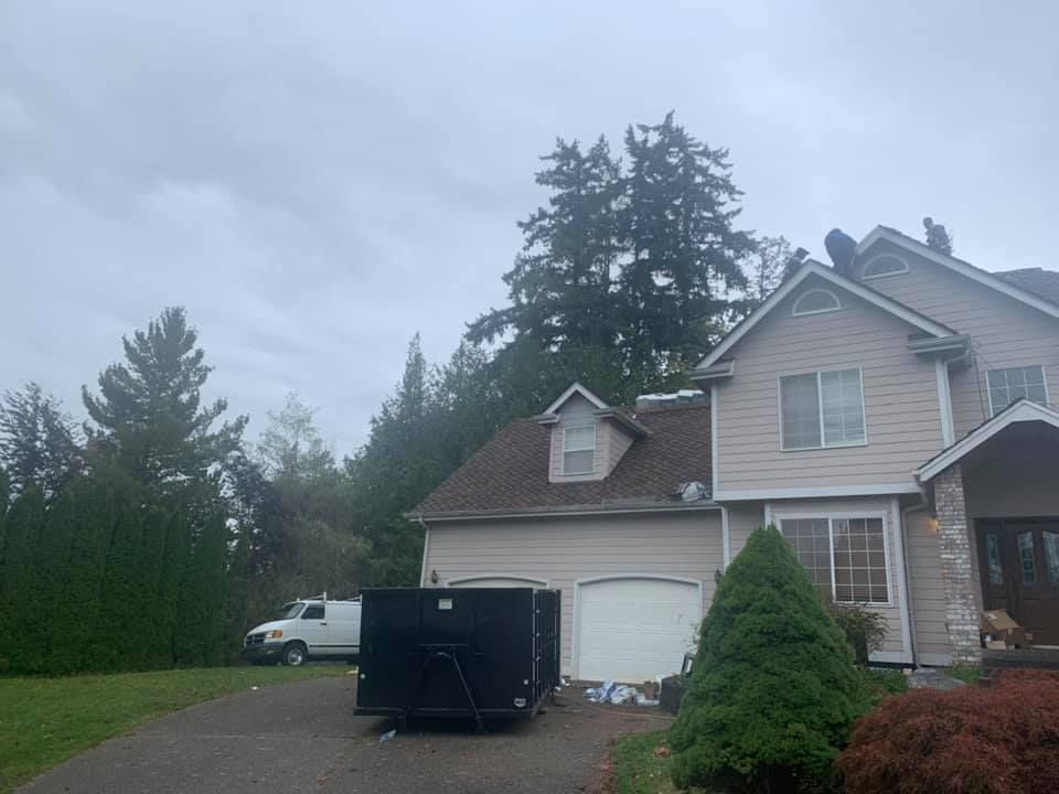 A large house with a dumpster in front of it.
