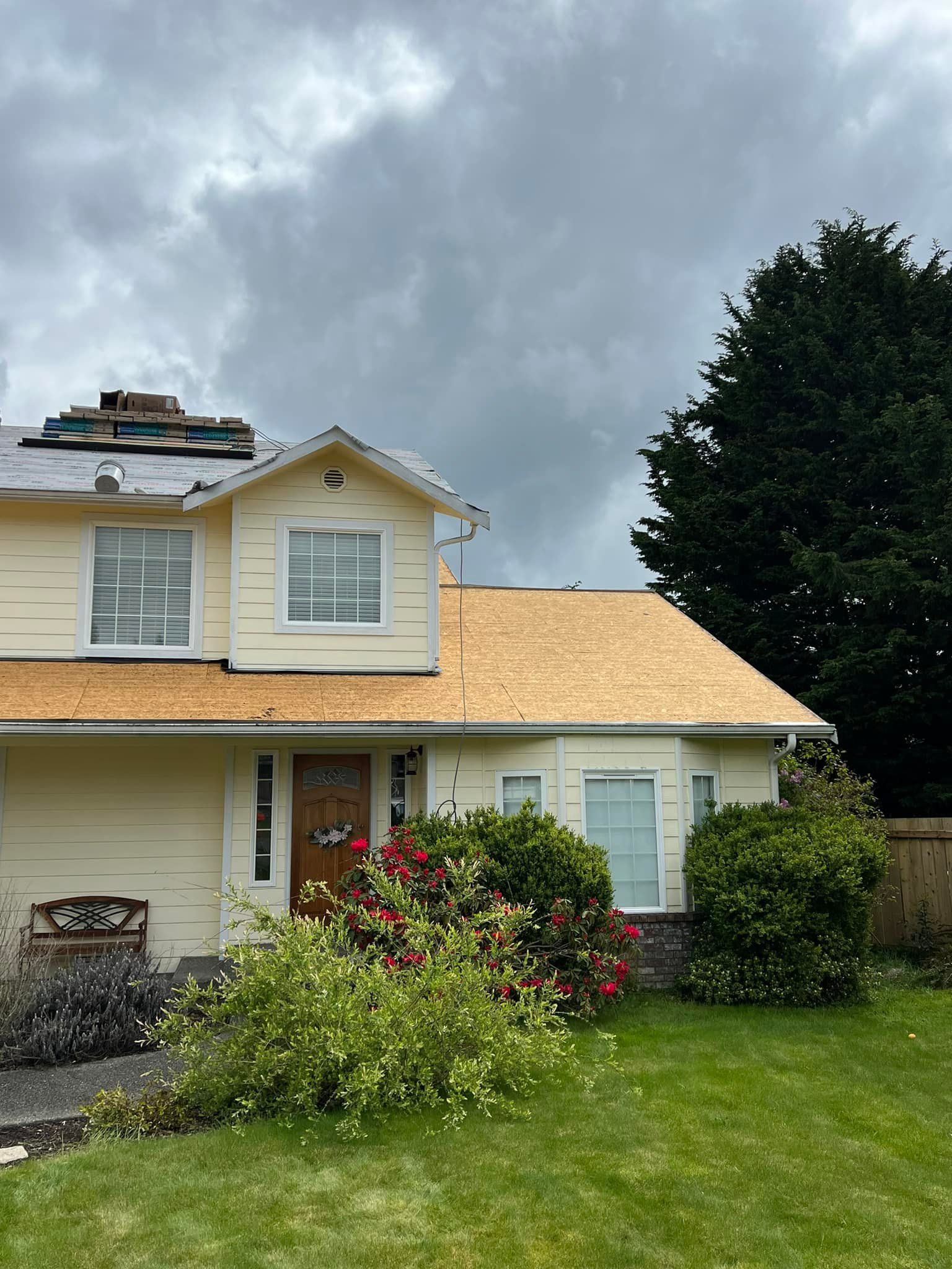 A house with a roof that is being installed on a cloudy day.
