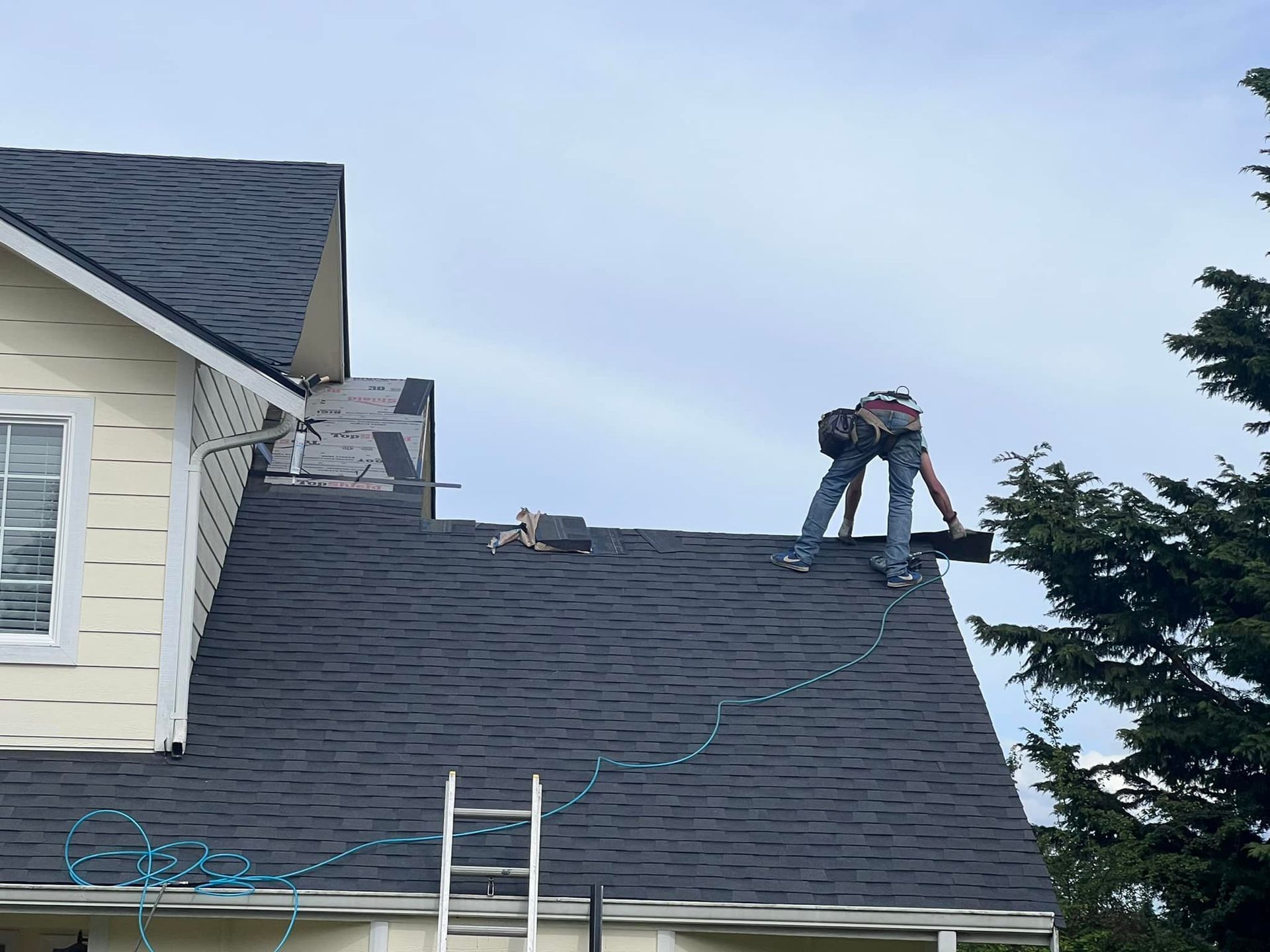 A man is working on the roof of a house.