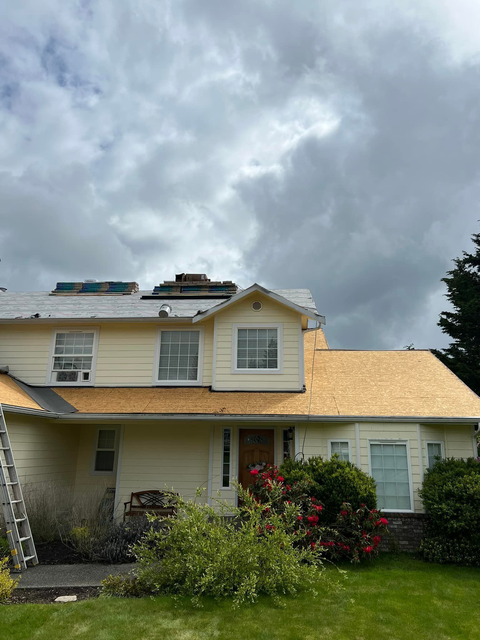 A white house with a wooden roof is being remodeled.