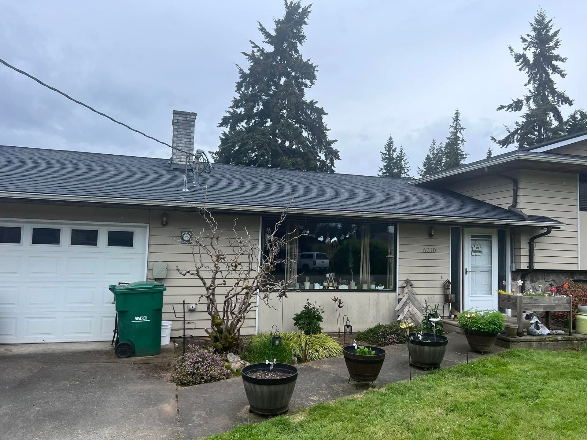 A house with a green trash can in front of it
