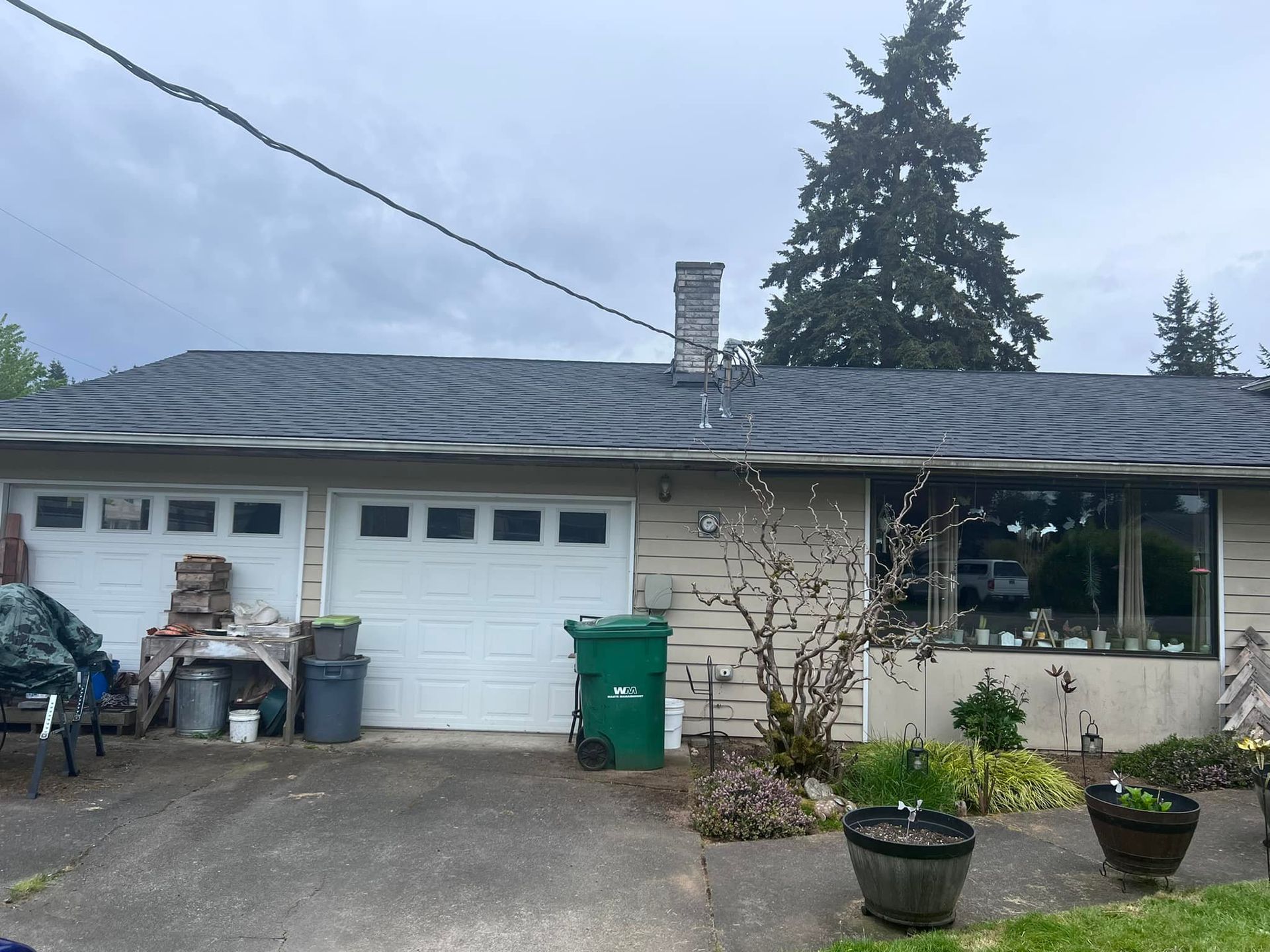 A house with a green trash can in front of it