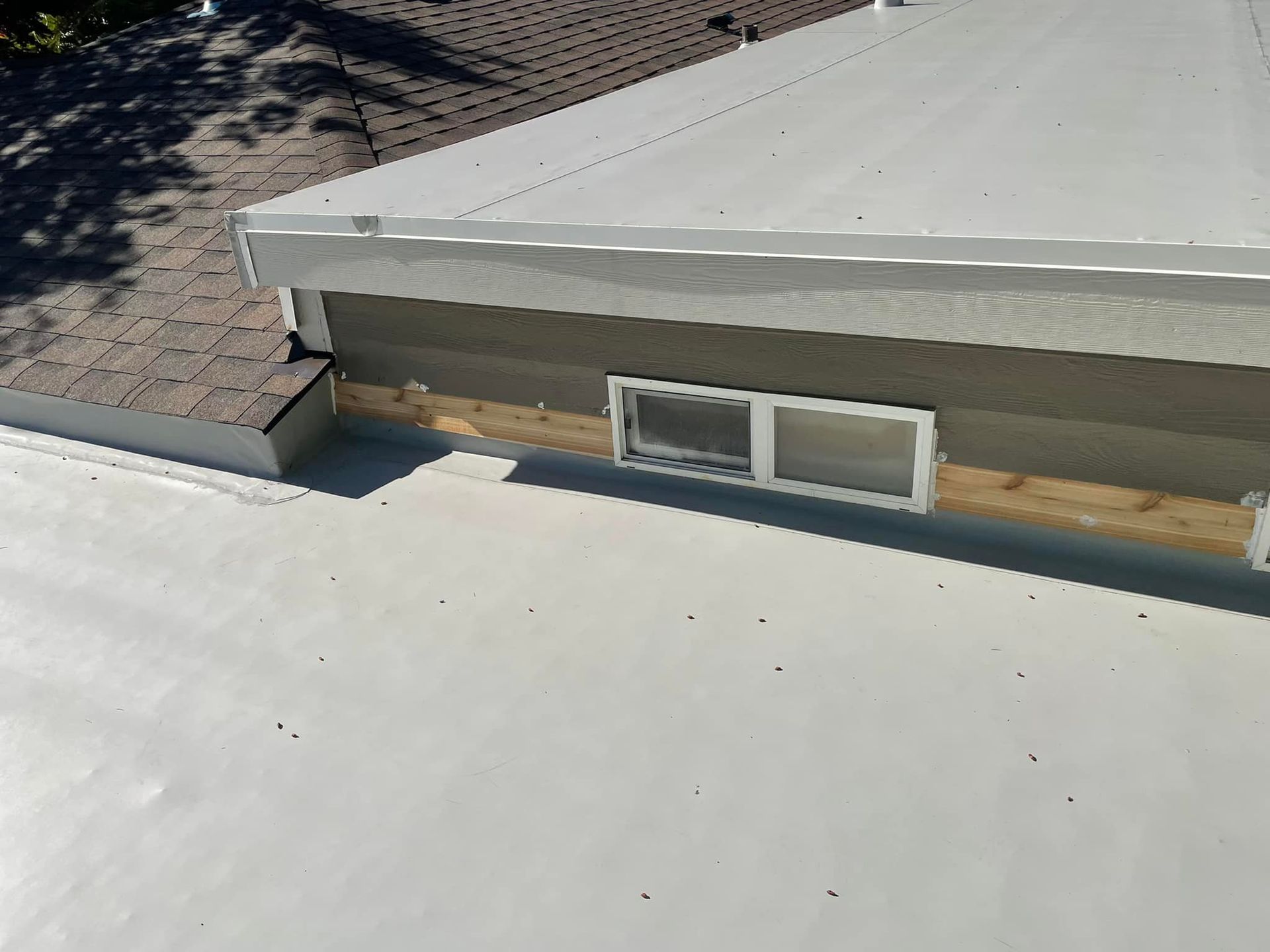 An aerial view of a house with a white roof and a window.