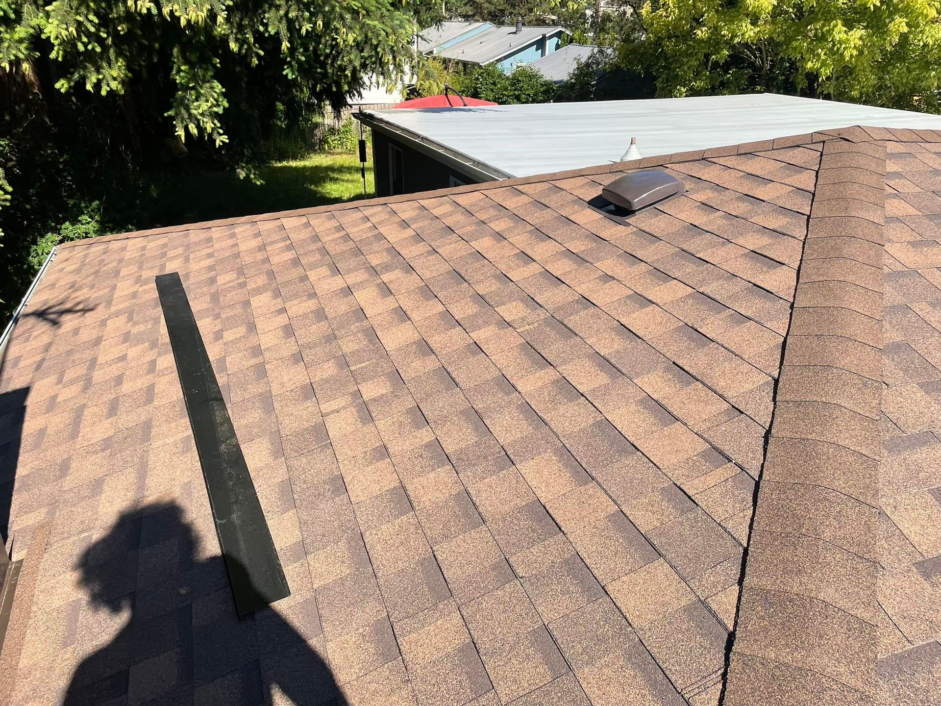 A close up of a roof with a shadow of a person on it.