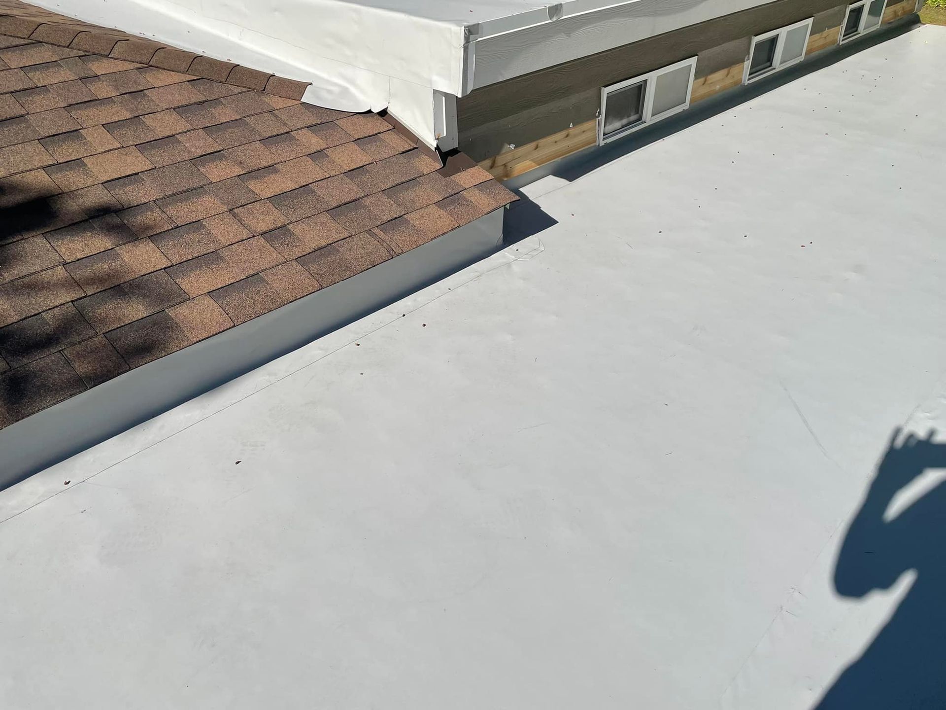 A white roof with a brown roof next to it.
