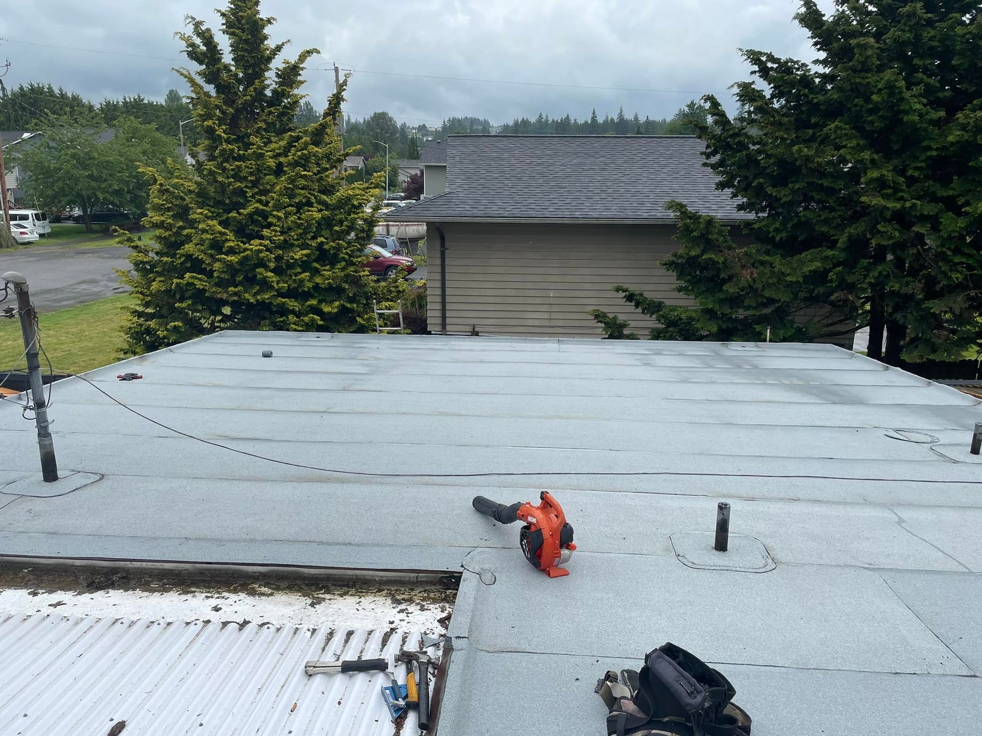 A roof with a chainsaw on it and trees in the background