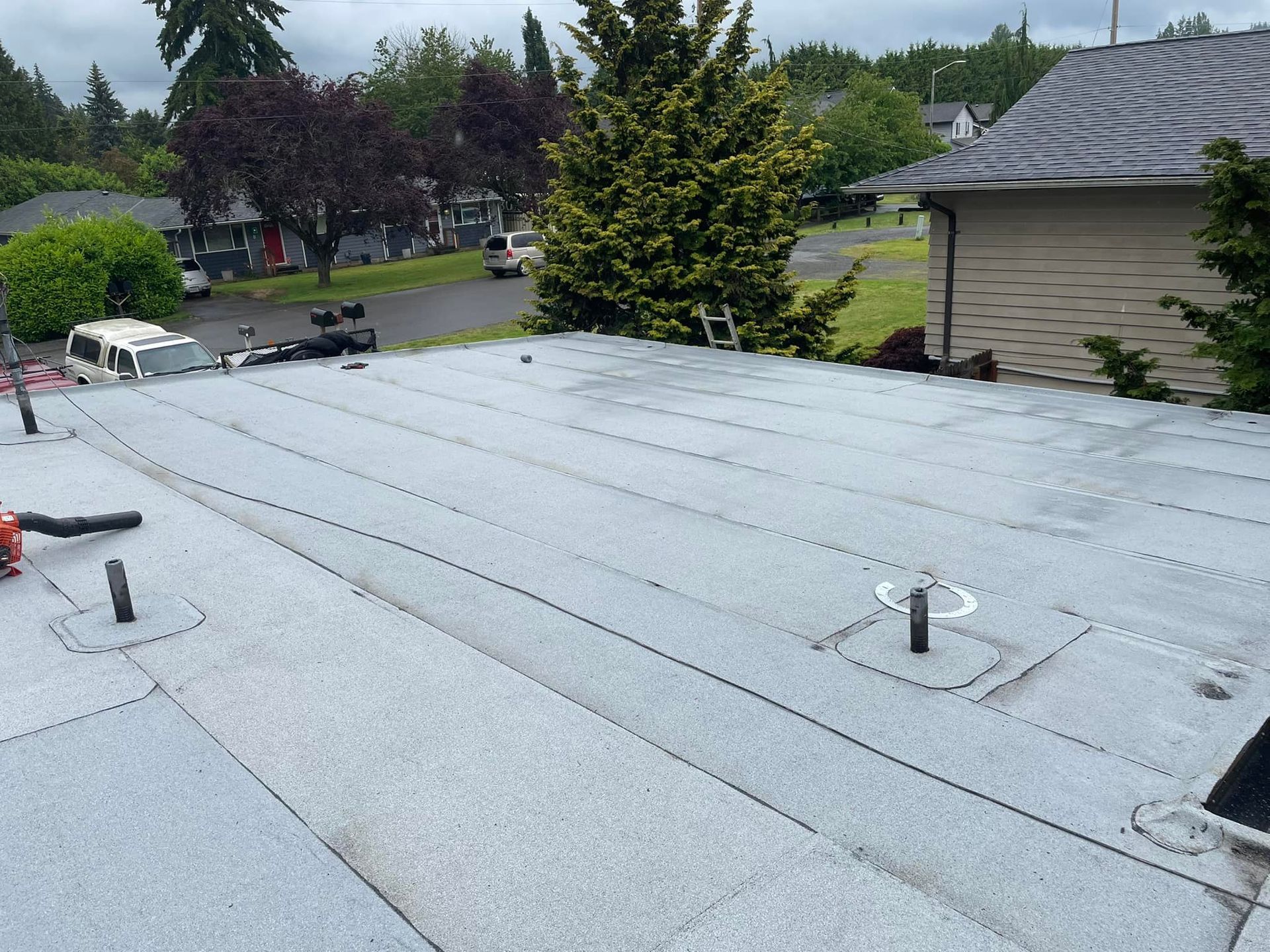 A roof of a house with a few trees in the background