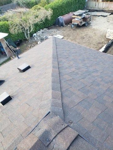 An aerial view of a roof with shingles being installed.