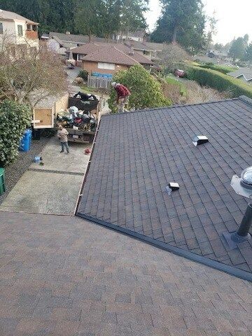 A man is working on the roof of a house.