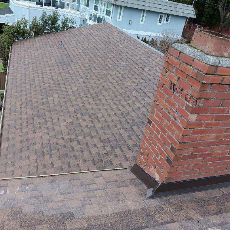 A roof with a brick chimney on top of it.