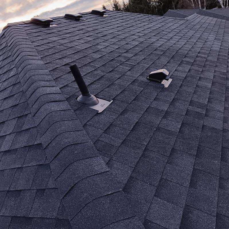 A close up of a roof with a chimney on it.