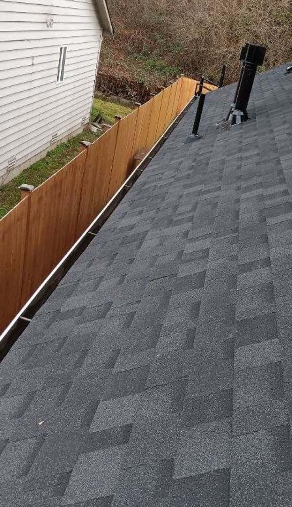 A roof with a wooden fence and a chimney on it.