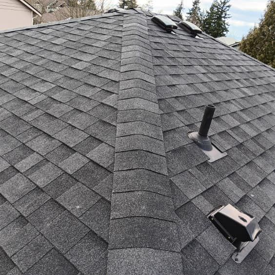 A close up of a roof with shingles and a chimney.