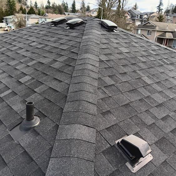 A roof with a lot of shingles and a vent on it.