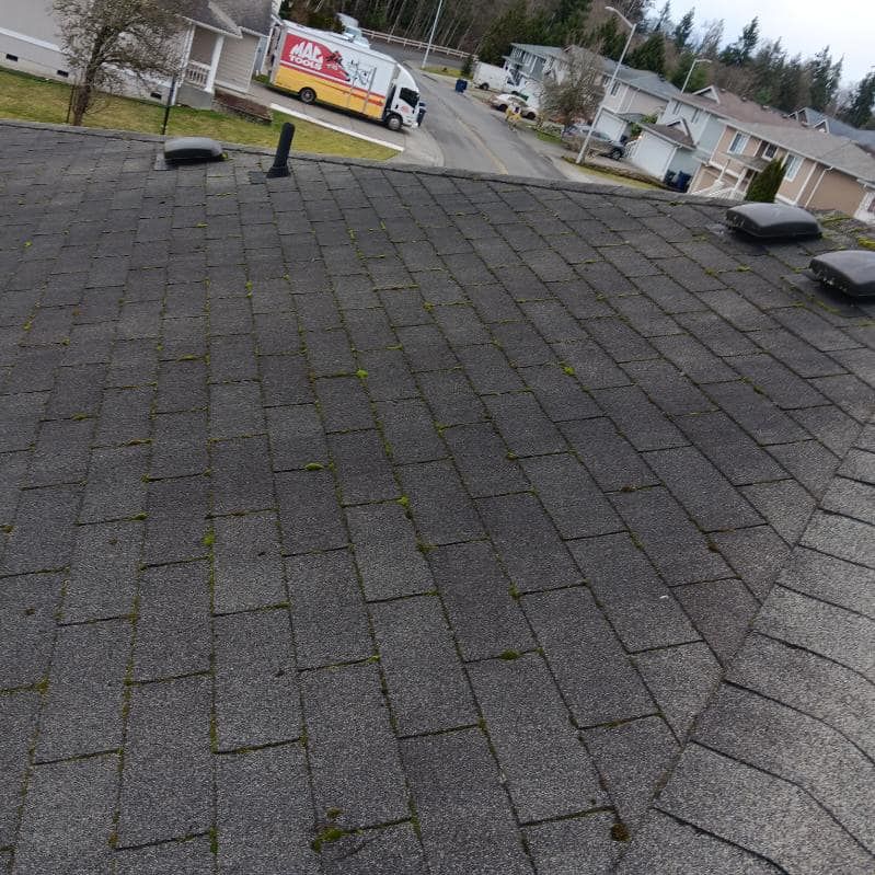 A truck is parked on the roof of a house in a residential area.