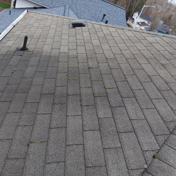 The roof of a house with a gray shingle roof