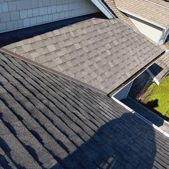 The roof of a house with a shadow of a person on it.