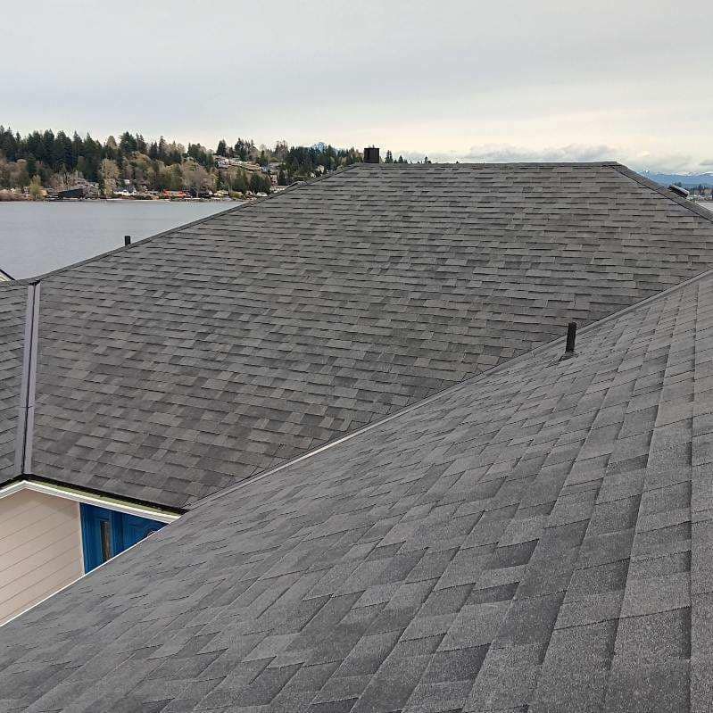 The roof of a house with a view of a lake.