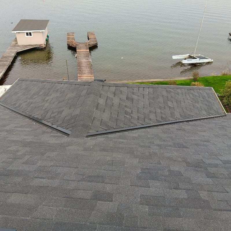 A roof with a dock and a boat in the water.