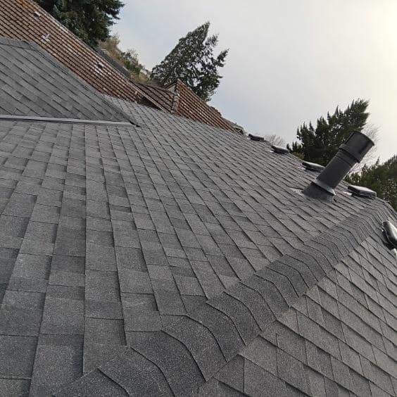 A roof with a lot of shingles and a chimney on it.