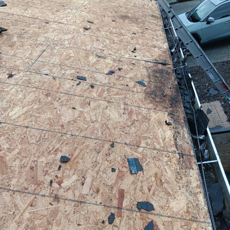 A close up of a roof with a car parked in the background.