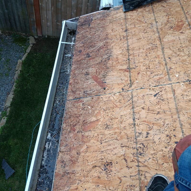 A person is standing on the roof of a house