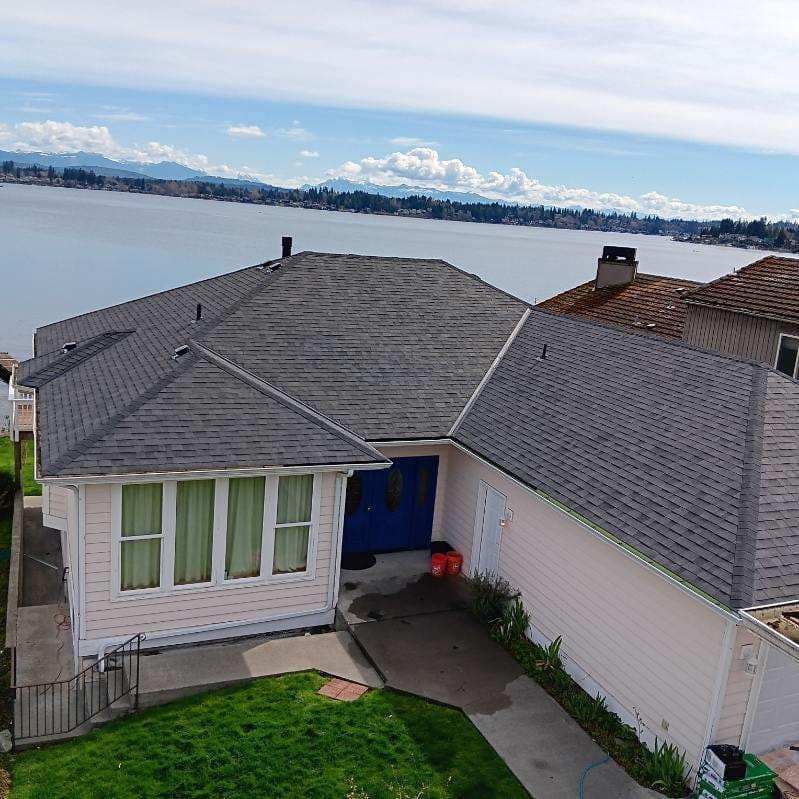An aerial view of a house next to a body of water