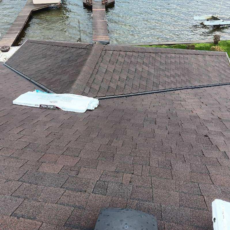 A roof with a view of a lake and a dock.
