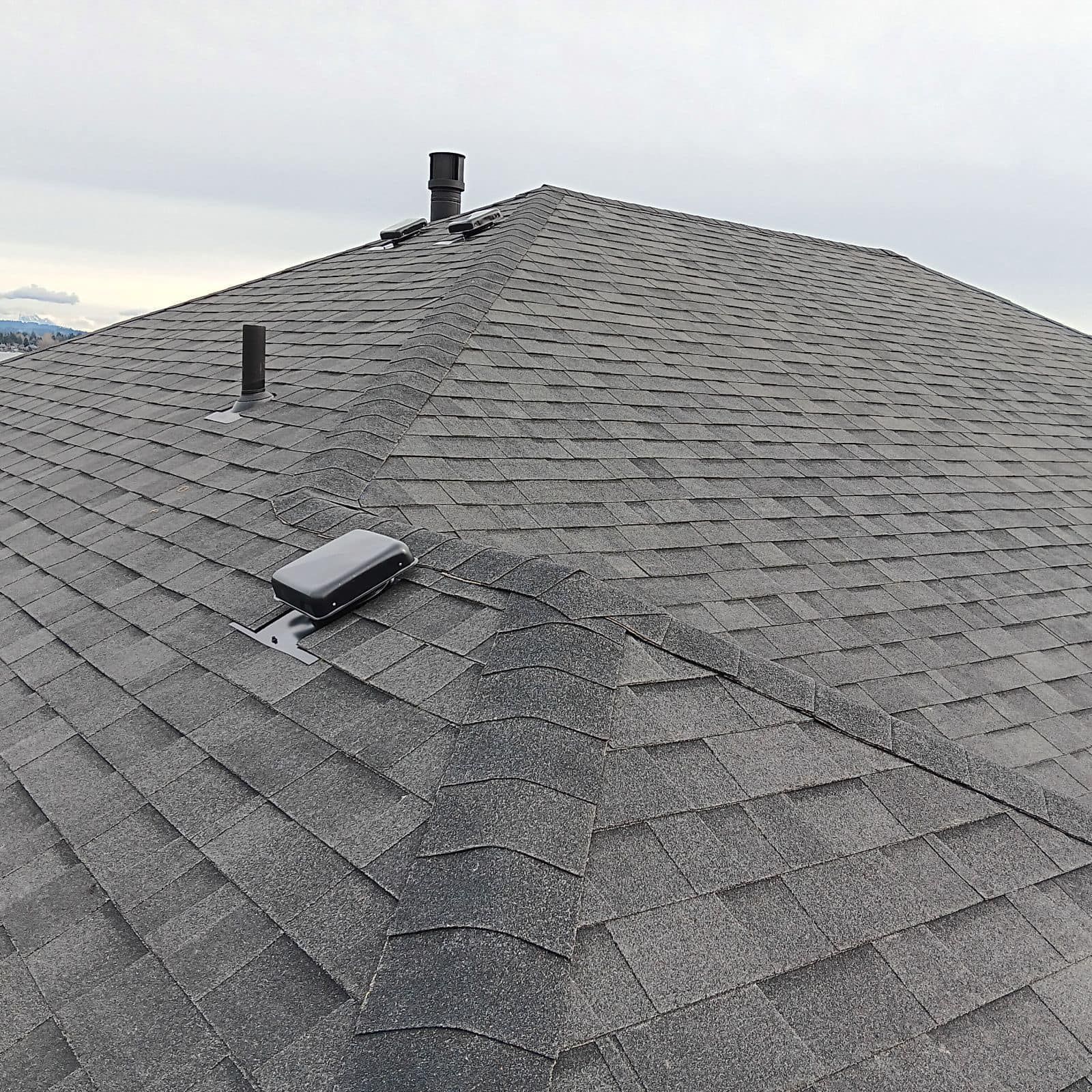 A roof with a lot of shingles and a chimney on it.