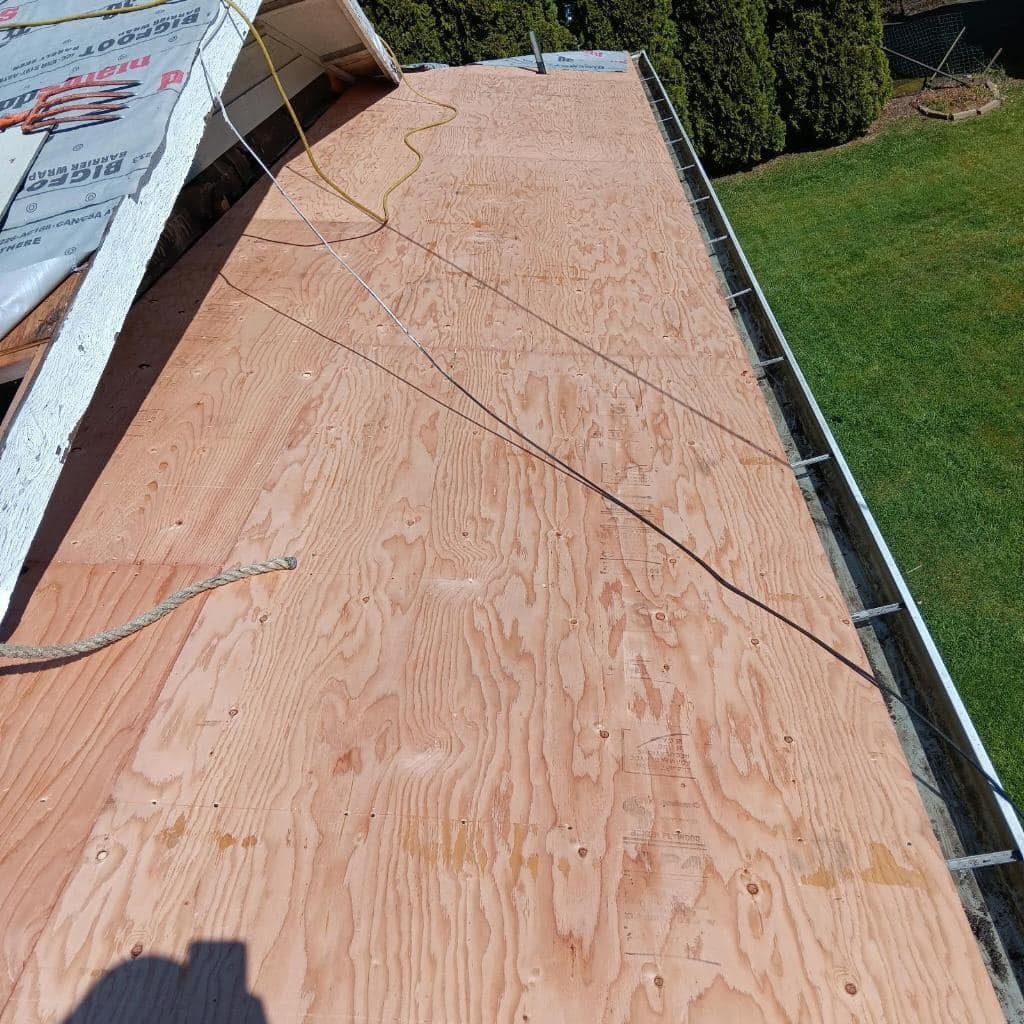 A roof with a lot of plywood on it and a gutter.