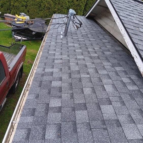 A red truck is parked on the roof of a house.