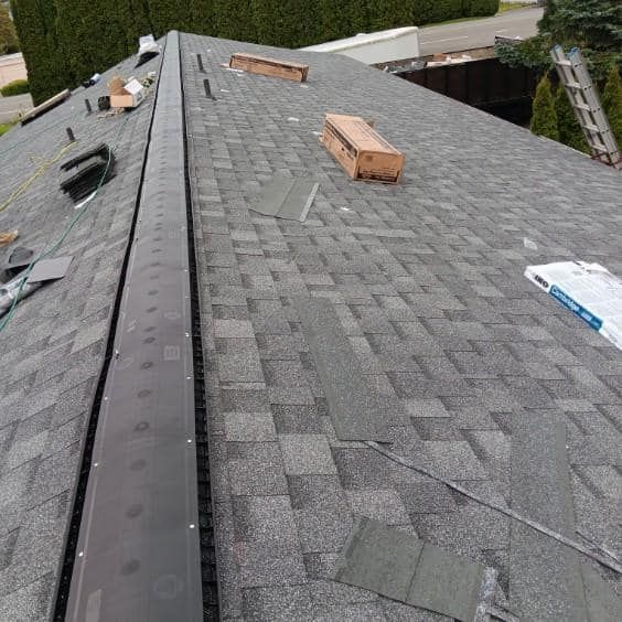 A roof with shingles and a ladder on it.