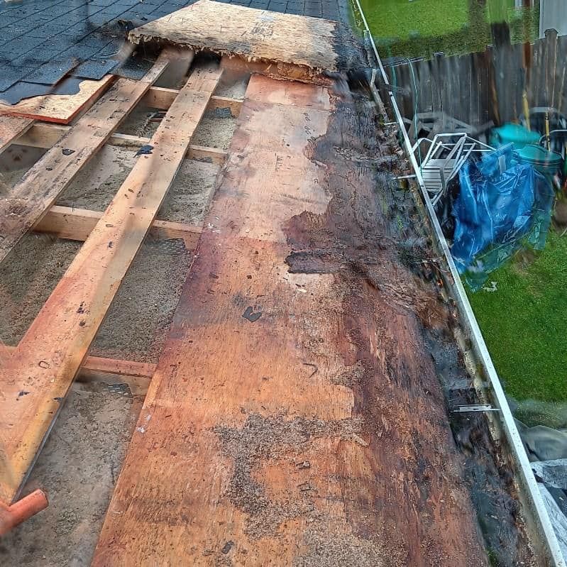 A roof is being repaired with wooden beams and shingles.
