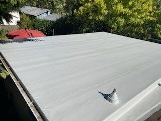 A white roof with a red umbrella in the background.
