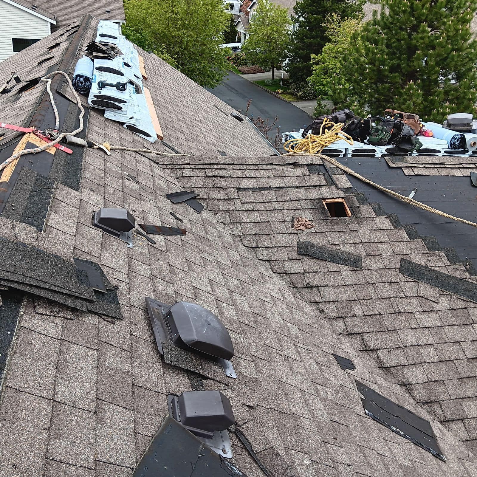 A roof with a lot of shingles on it is being repaired.