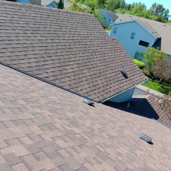 The roof of a house with a brown shingle roof
