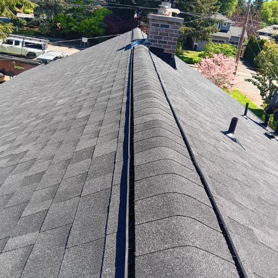 A close up of a roof with shingles and a chimney.