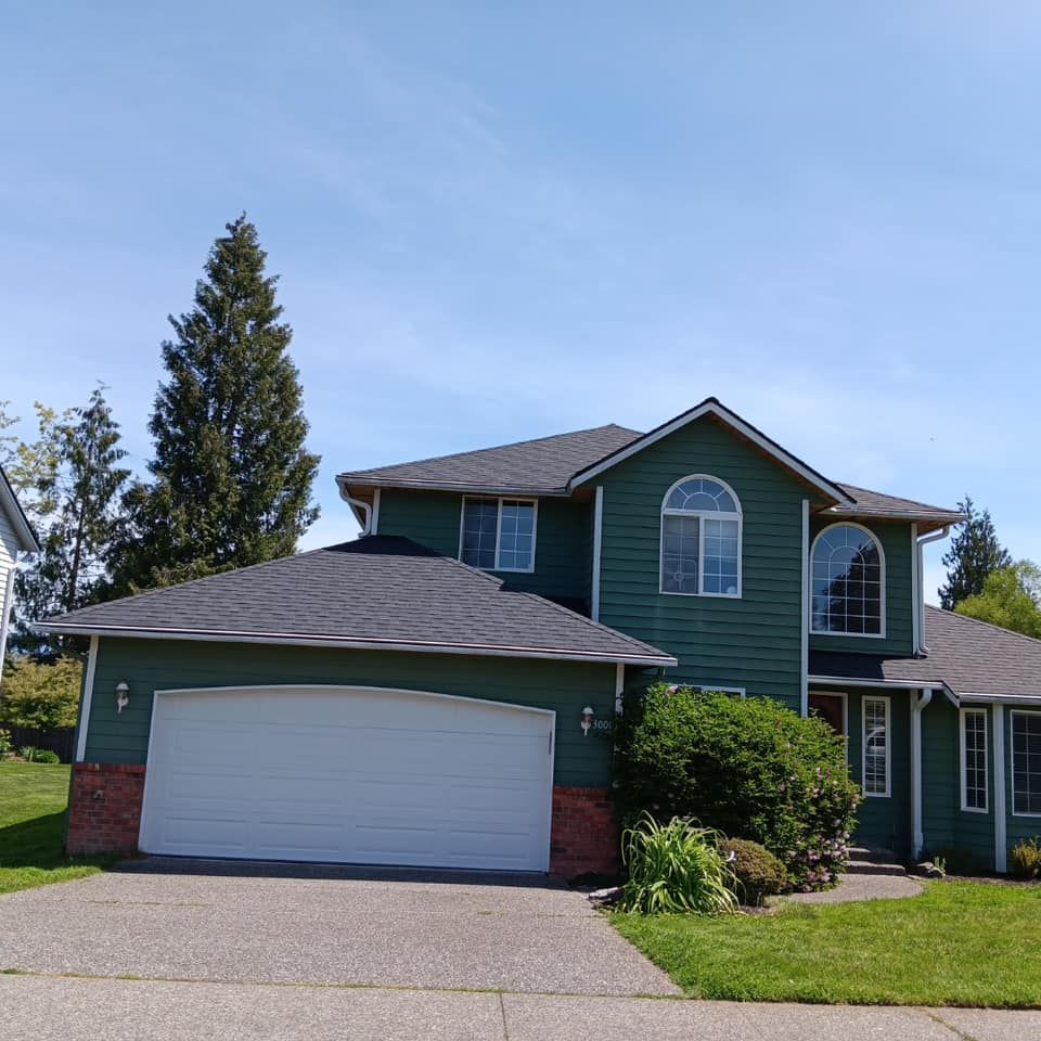 A green house with a white garage door